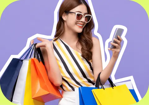 Shopper holding shopping bags and a mobile phone